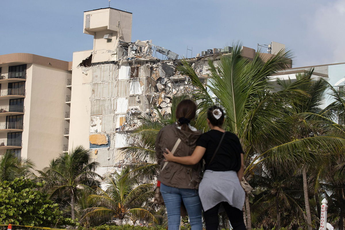 <i>Joe Raedle/Getty Images</i><br/>Maria Fernanda Martinez and Mariana Cordeiro look on as search and rescue operations continue at the site of the partially collapsed 12-story condo building on Friday in Surfsid