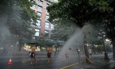 A temporary misting station in Vancouver cools residents amid the extreme heat.