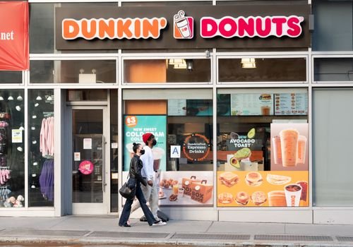 Customers walk up to a Dunkin' Donuts location.
