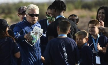 Richard Branson receives some cards from children as he walks out from Spaceport America