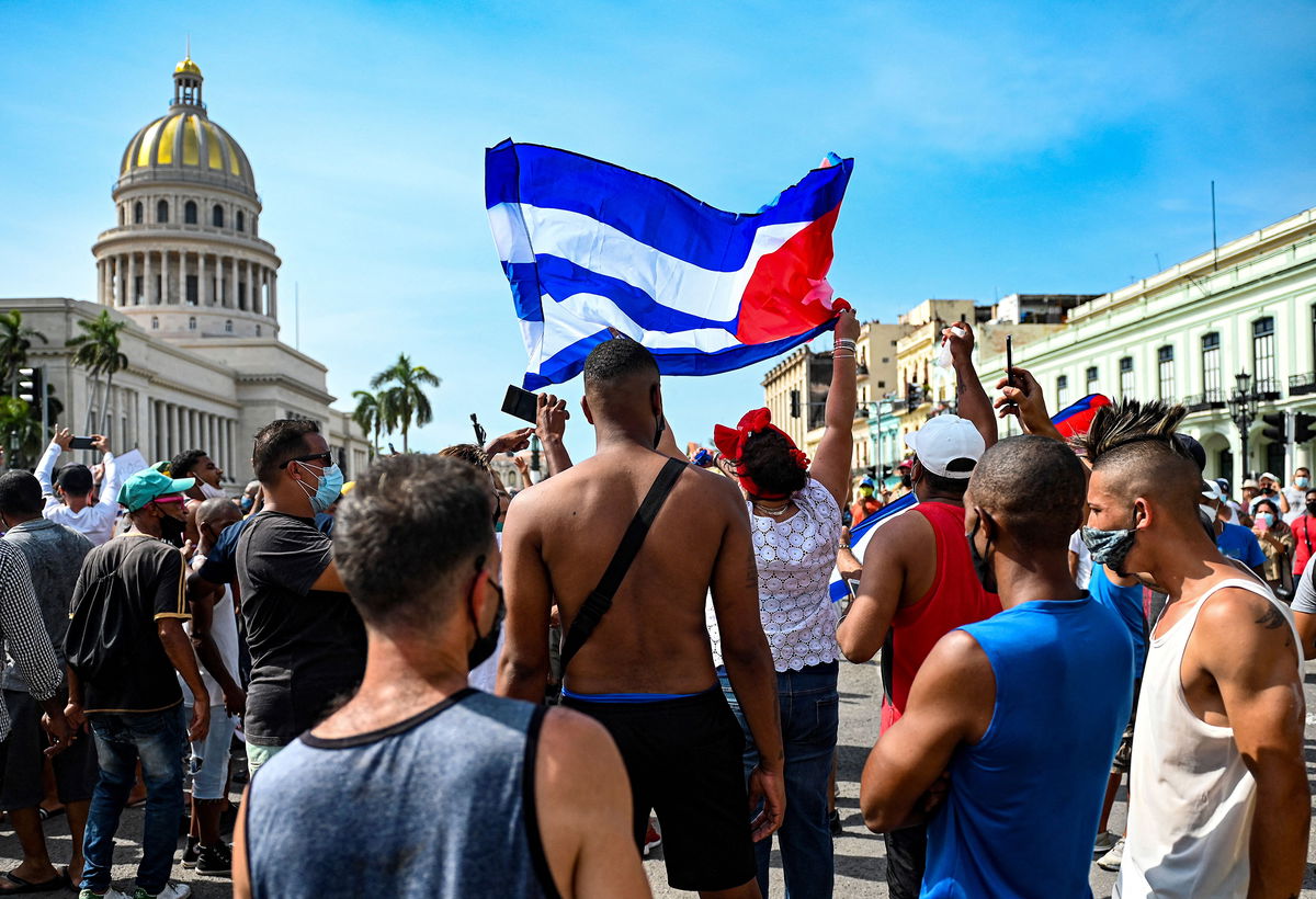 TOPSHOT - Cubans are seen outside Havana's Capitol during a demonstration against the government of Cuban President Miguel Diaz-Canel in Havana, on July 11, 2021. - Thousands of Cubans took part in rare protests Sunday against the communist government, marching through a town chanting 