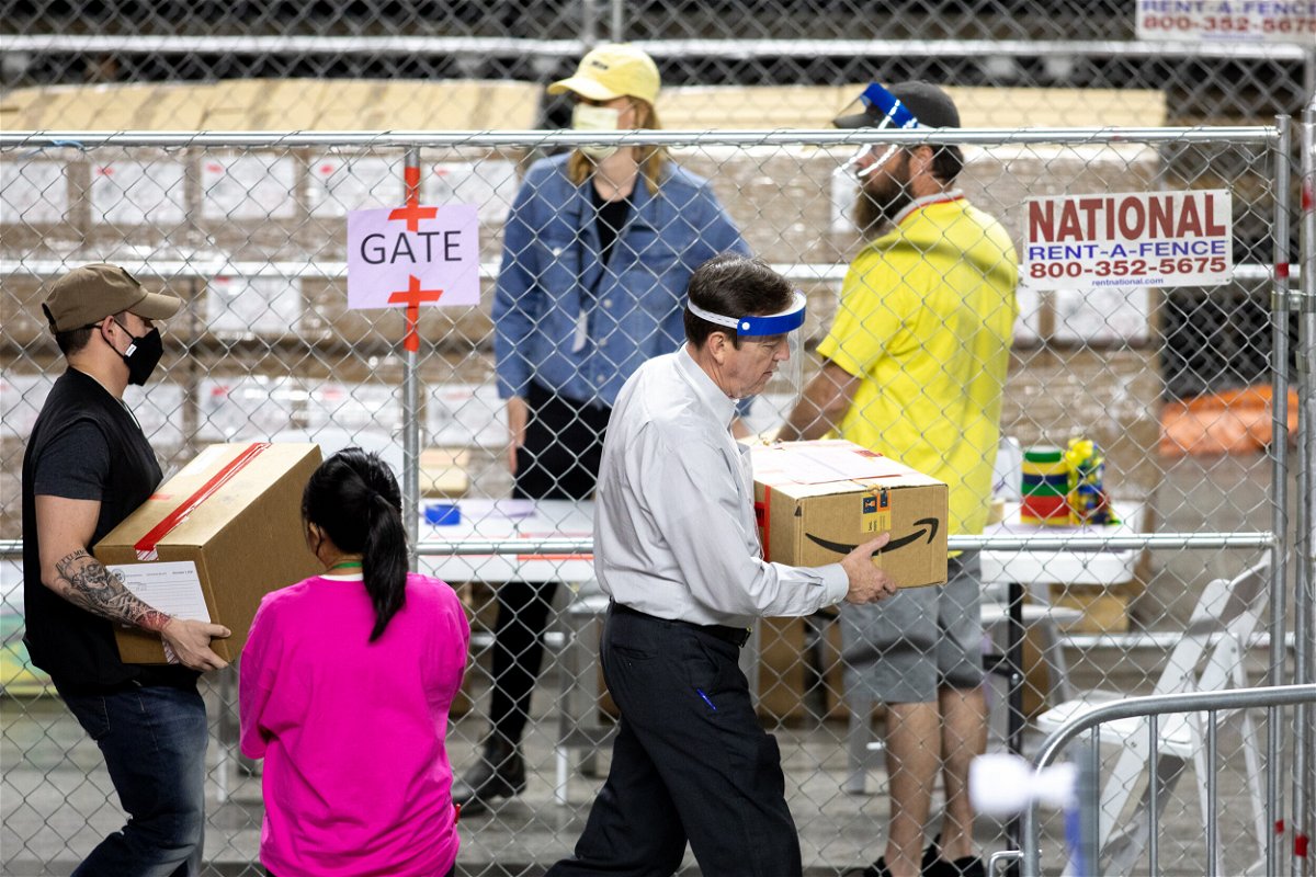 <i>Courtney Pedroza/Getty Images</i><br/>Former Arizona Secretary of State Ken Bennett (right) works to move ballots from the 2020 general election at Veterans Memorial Coliseum on May 1 in Phoenix