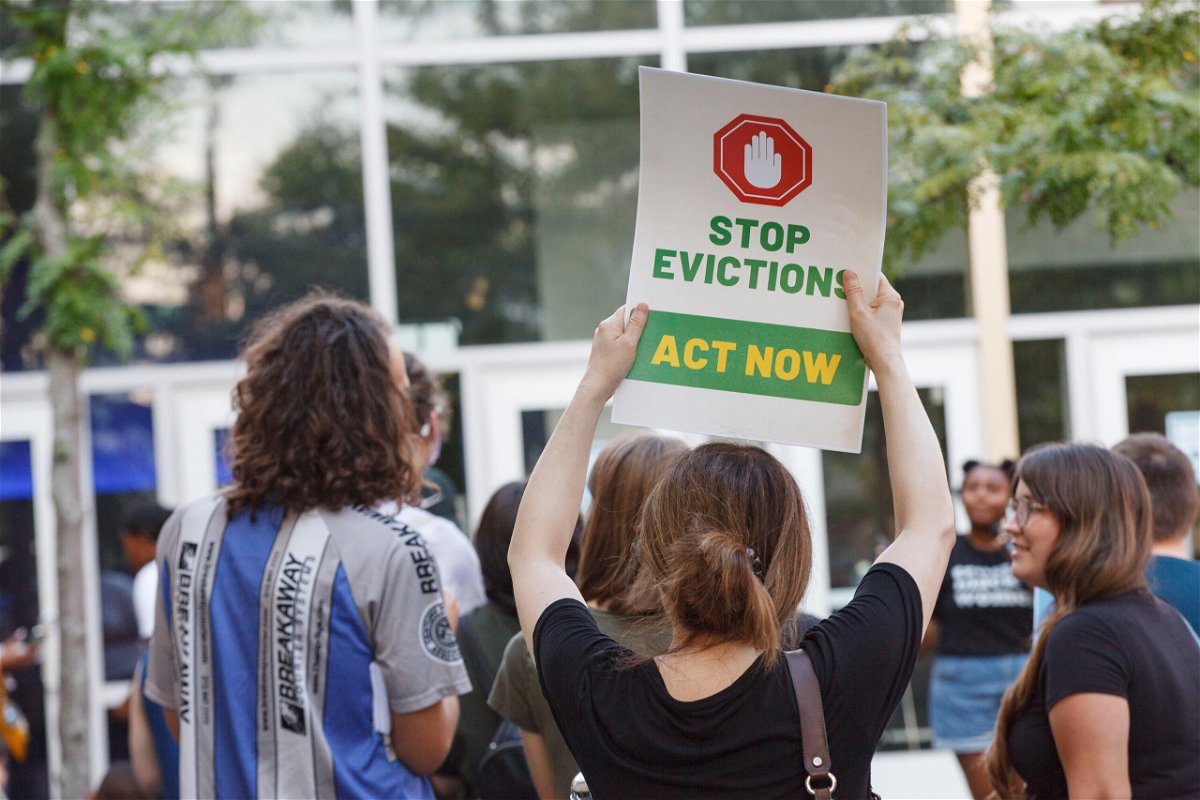 <i>Stephen Zenner/SOPA Images/LightRocket/Getty Images</i><br/>A woman holds a placard to stop evictions at a rally for housing reform.