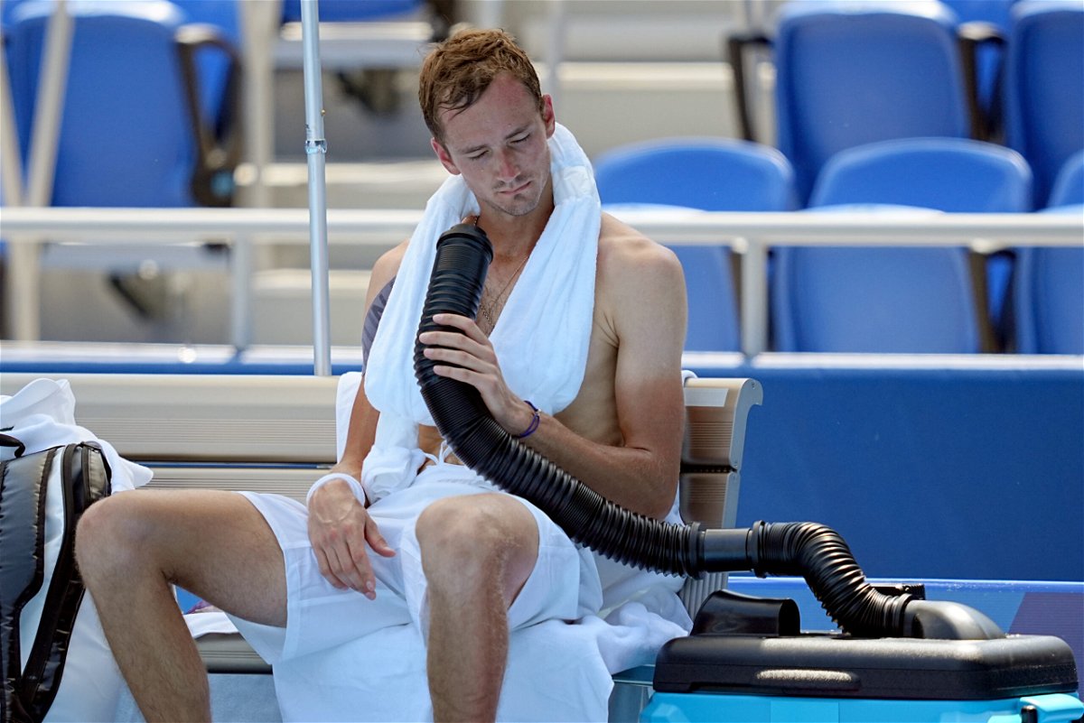 <i>Michael Kappeler/dpa/picture alliance/Getty Images</i><br/>Daniil Medvedev cools down during the break by using a mobile air conditioner and a towel with ice cubes at the Ariake Tennis Park on Saturday.