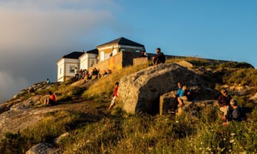 Pilgrims and tourists are seen waiting for the sunset at the Cape Finisterre. Cape Finisterre is the destination of those pilgrims who