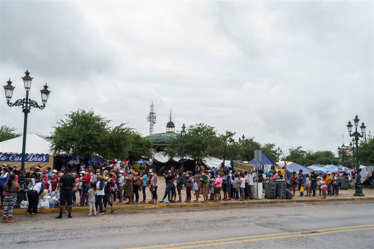 <i>Paul Ratje/AFP/Getty Images</i><br/>Migrants who were sent back to Mexico under Title 42 wait in line for food and supplies in a camp across the US-Mexico border earlier this month.