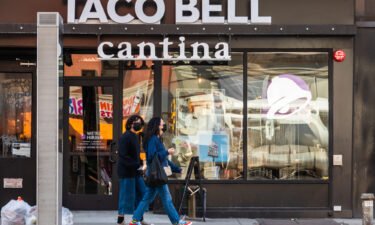 Two people wearing masks walk by a Taco Bell Cantina on March 21 in New York City. The chain apologized on its website July 20