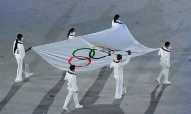The Olympic flag is seen being carried during the opening ceremony of the Tokyo 2020 Olympic Games at the Olympic Stadium in Tokyo on July 23.