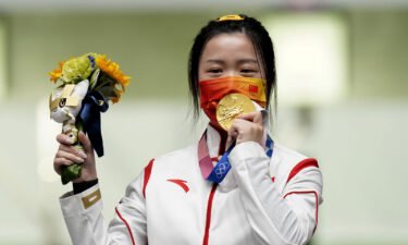 China's Yang Qian celebrates with her gold medal after winning the 10m Air Rifle Women's Final on the first day of the Tokyo 2020 Olympic Games.