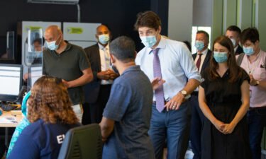 Canada's Prime Minister Justin Trudeau greets people as he visits a vaccination site in Montreal