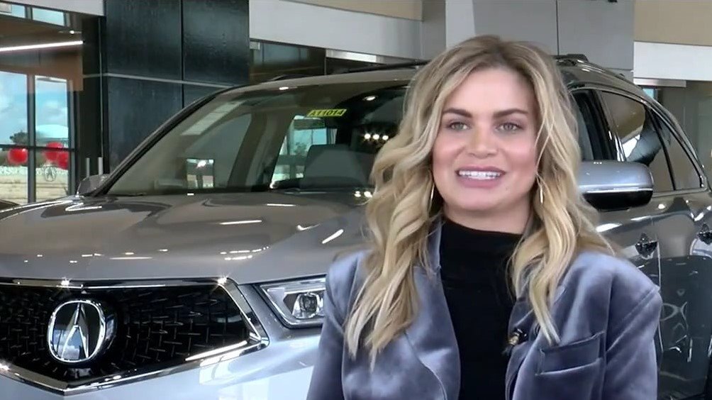 Paige Fox poses in front of a vehicle at her Acura dealership.