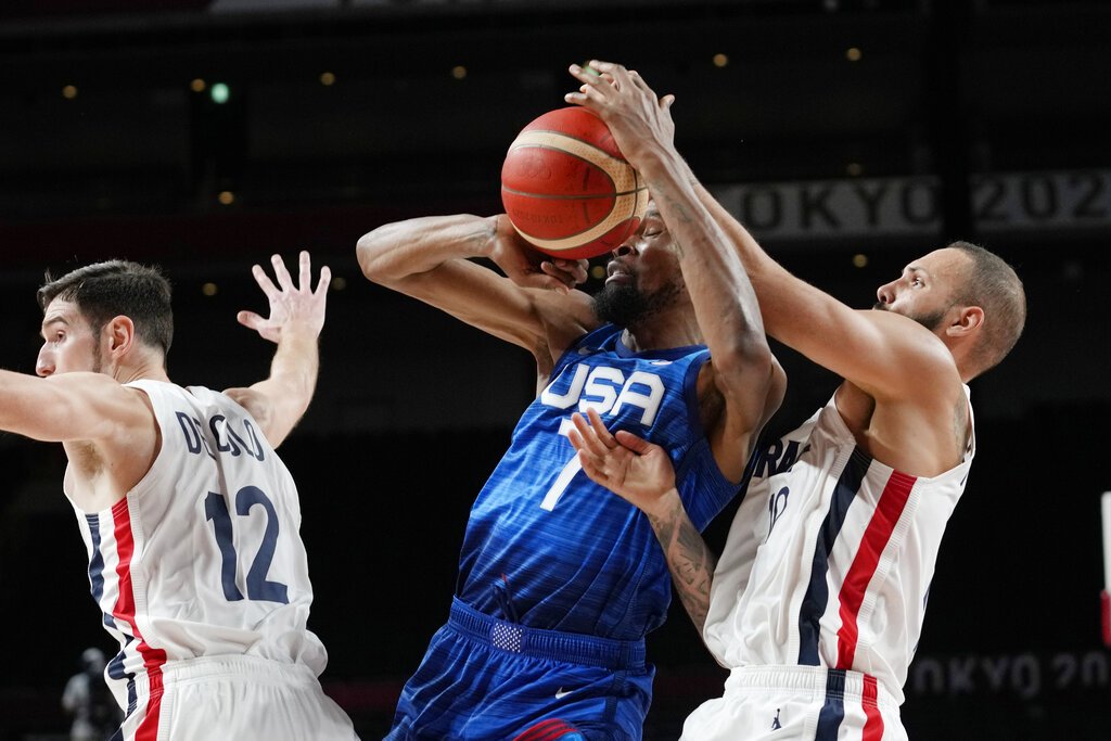 United States' forward Kevin Durant (7) and France's Evan Fournier, right, fight for control of the ball during a men's basketball game at the Summer Olympics.