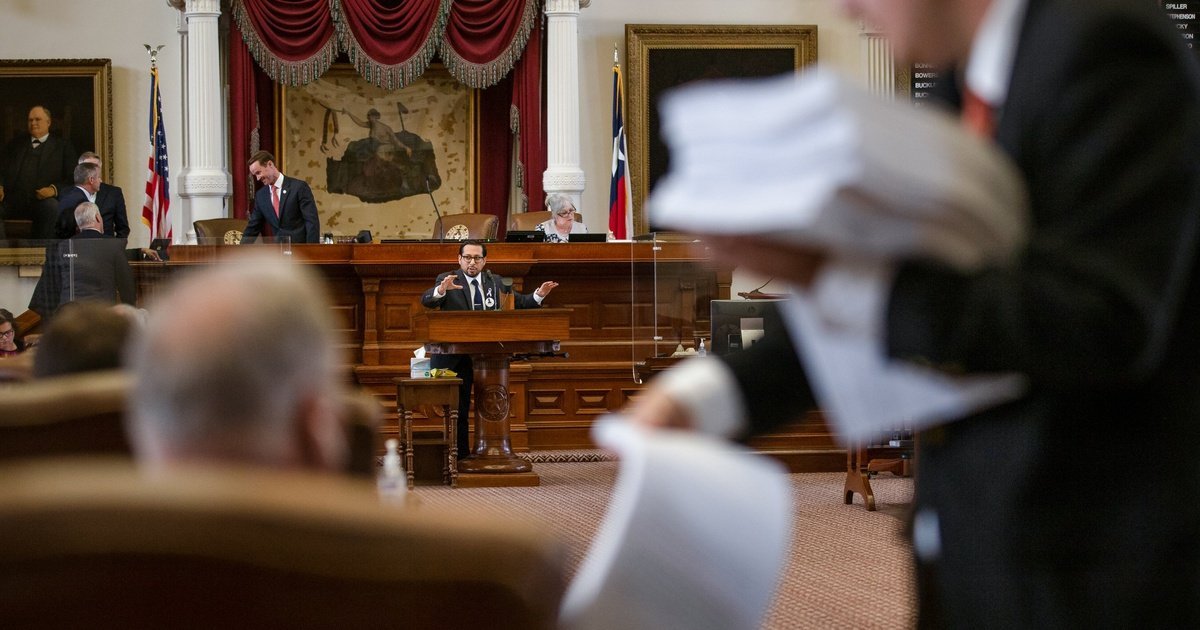 A staffer passes out papers during a past session on the House floor at the Texas state capitol.