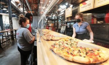 Ian's Pizza worker Stella Klein serves customers Olivia Rebholz and Randy Bland at the restaurant's Garver Feed Mill location. Only three of the chain's seven restaurants were approved for federal COVID-19 grant assistance.
