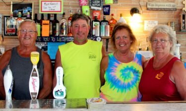 The last two sets of owners of Leipsic Tavern pose behind the bar: Danny Schmitt