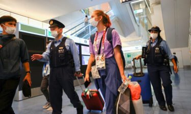 Kristina Timanovskaya is escorted by police officers at Haneda international airport in Tokyo