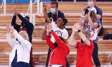 Simone Biles cheers with teammates Jordan Chiles (left) and Grace McCallum (right) from the stands during the women's vault final.