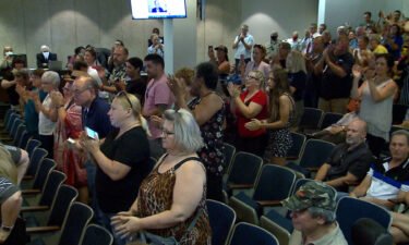 Officials say a person who attended a St. Louis County Council meeting where officials voted to overturn a mask mandate has tested positive for Covid-19 as many attendees pictured here at the St. Louis County Council meeting weren't wearing masks.