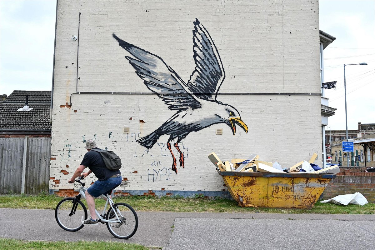 <i>Justin Tallis/AFP/Getty Images</i><br/>A cyclist rides past a stensil of a gull about to swoop down onto a carton of chips