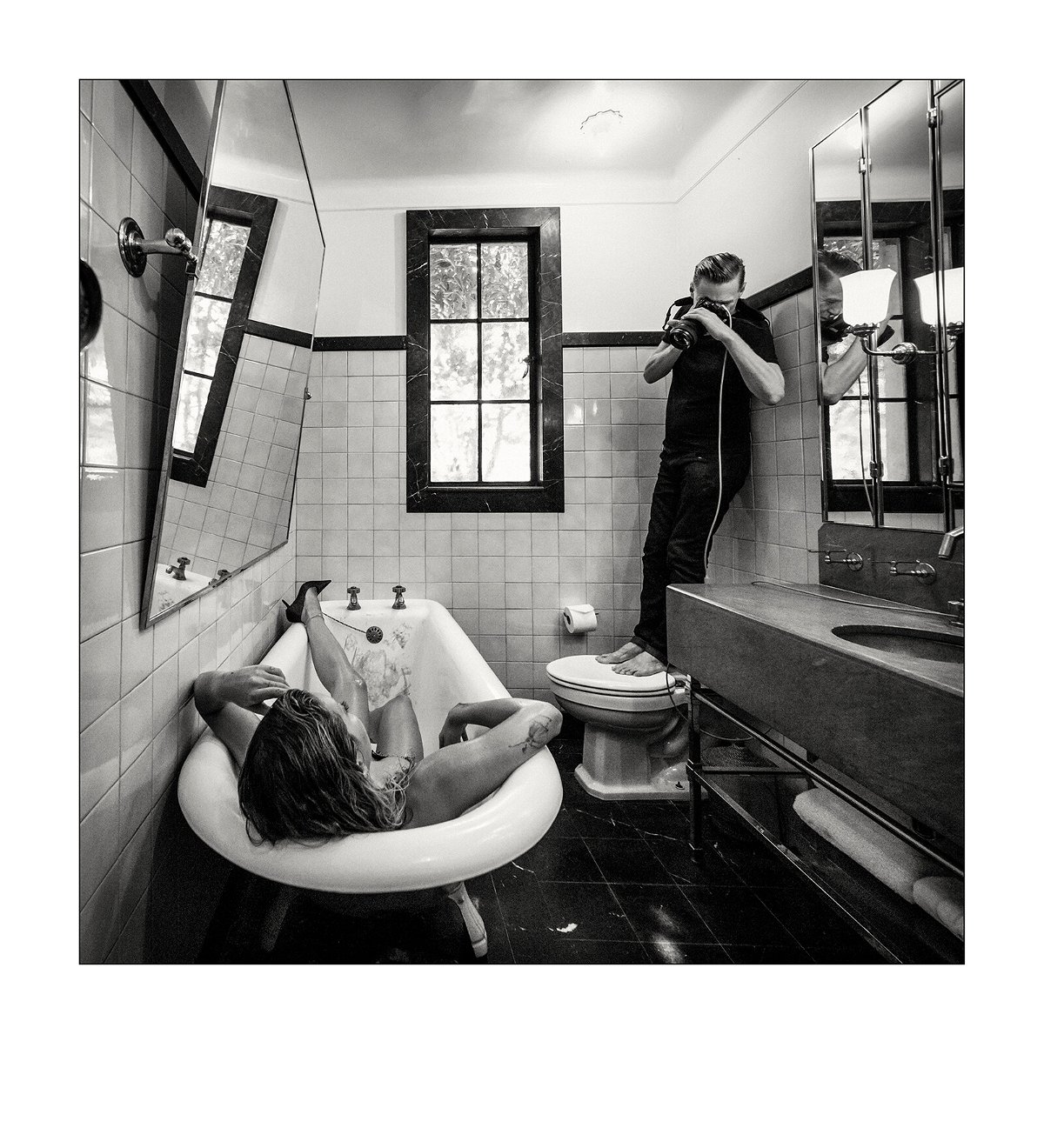 <i>Alessandro Scotti</i><br/>Rita Ora lies in a bathtub as photographer Bryan Adams shoots her from afar.