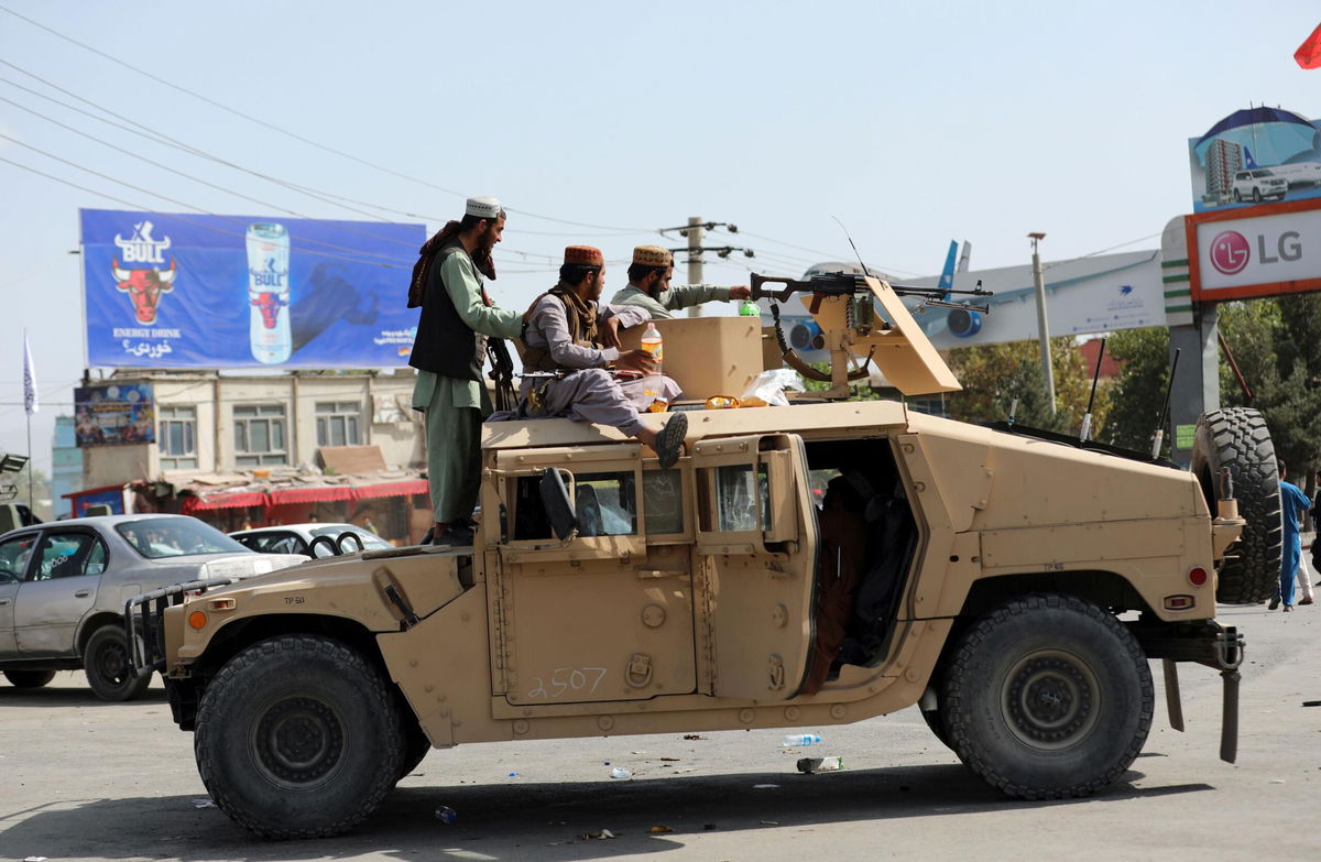 Taliban fighters drive an American Humvee in Kabul.