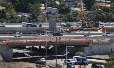Construction workers build the "Signature Bridge