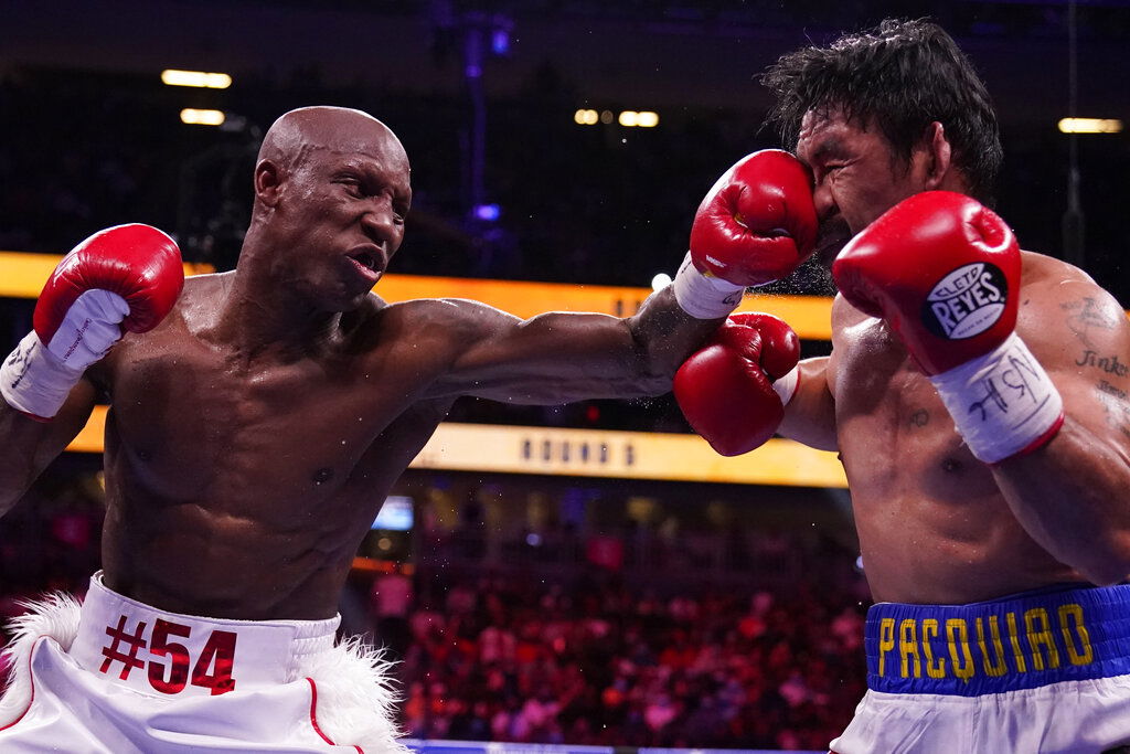 Yordenis Ugas, left, of Cuba, hits Manny Pacquiao, of the Philippines, in a welterweight championship boxing match.