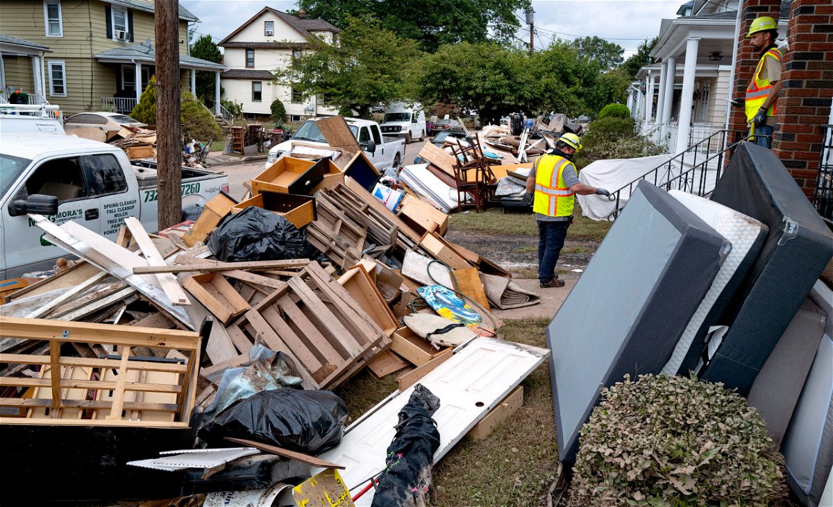 <i>Craig Ruttle/AP</i><br/>Utility workers work among debris from flood damage caused by the remnants of Hurricane Ida in Manville