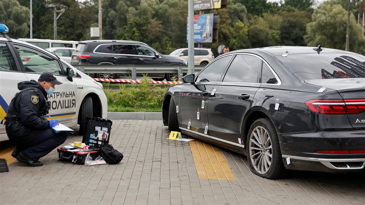 <i>Serhii Nuzhnenko/Reuters</i><br/>An investigator examines bullet holes in the car of Serhiy Shefir