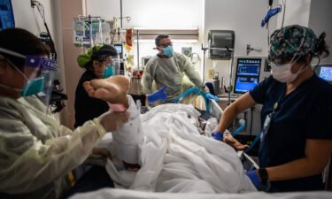 Health care workers attend to a patient with Covid-19 at the Cardiovascular Intensive Care Unit at Providence Cedars-Sinai Tarzana Medical Center in Tarzana