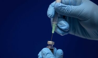 Sodium chloride is added to a vial of the Pfizer/BioNTech COVID-19 vaccine concentrate ready for administration at Guy's Hospital at the start of the largest ever immunization program in the UK's history in 2020 in London