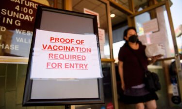 A sign stating proof of a Covid-19 vaccination is required is displayed outside of Langer's Deli in Los Angeles on August 7.