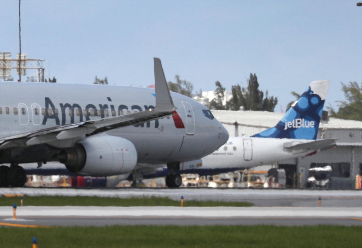 <i>Joe Raedle/Getty Images</i><br/>An American Airlines plane takes off near a parked JetBlue plane at the Fort Lauderdale-Hollywood International Airport.