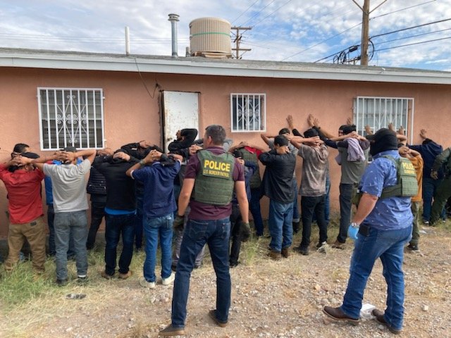 Border Patrol agents round up migrants found at a stash house.