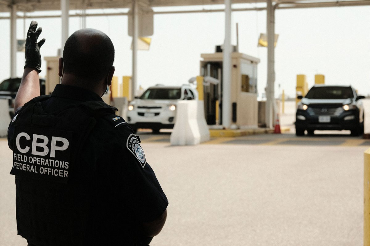 The United States plans to ease restrictions on travel for fully vaccinated visitors from Canada and Mexico starting in early November. U.S. Customs and Border Protection agents are shown directing vehicles re-entering the U.S. from Canada at the Ambassador Bridge Port of Entry August 9