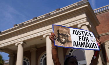 A demonstrator holds a sign at the Glynn County Courthouse as jury selection begins in the trial of Arbery's shooting death on October 18