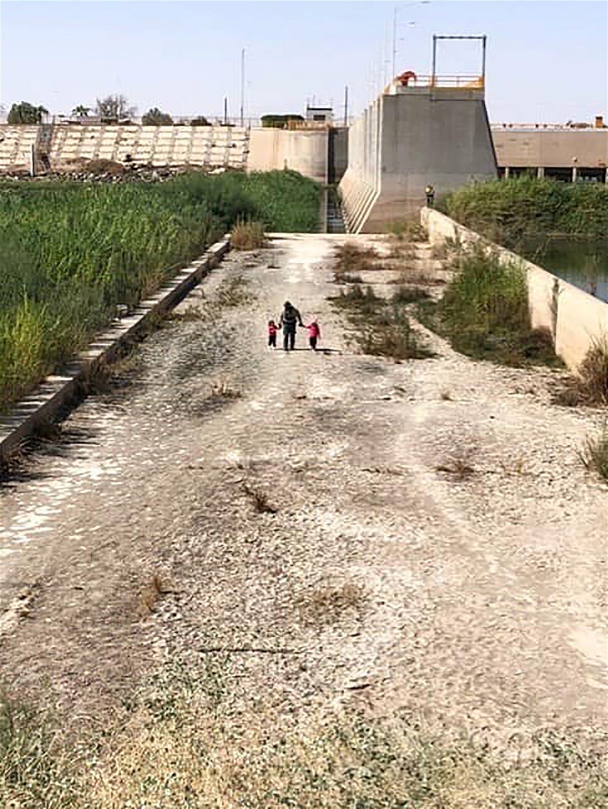 <i>US Border Patrol</i><br/>A US Border Patrol agent is seen walking with two young sisters found on October 12