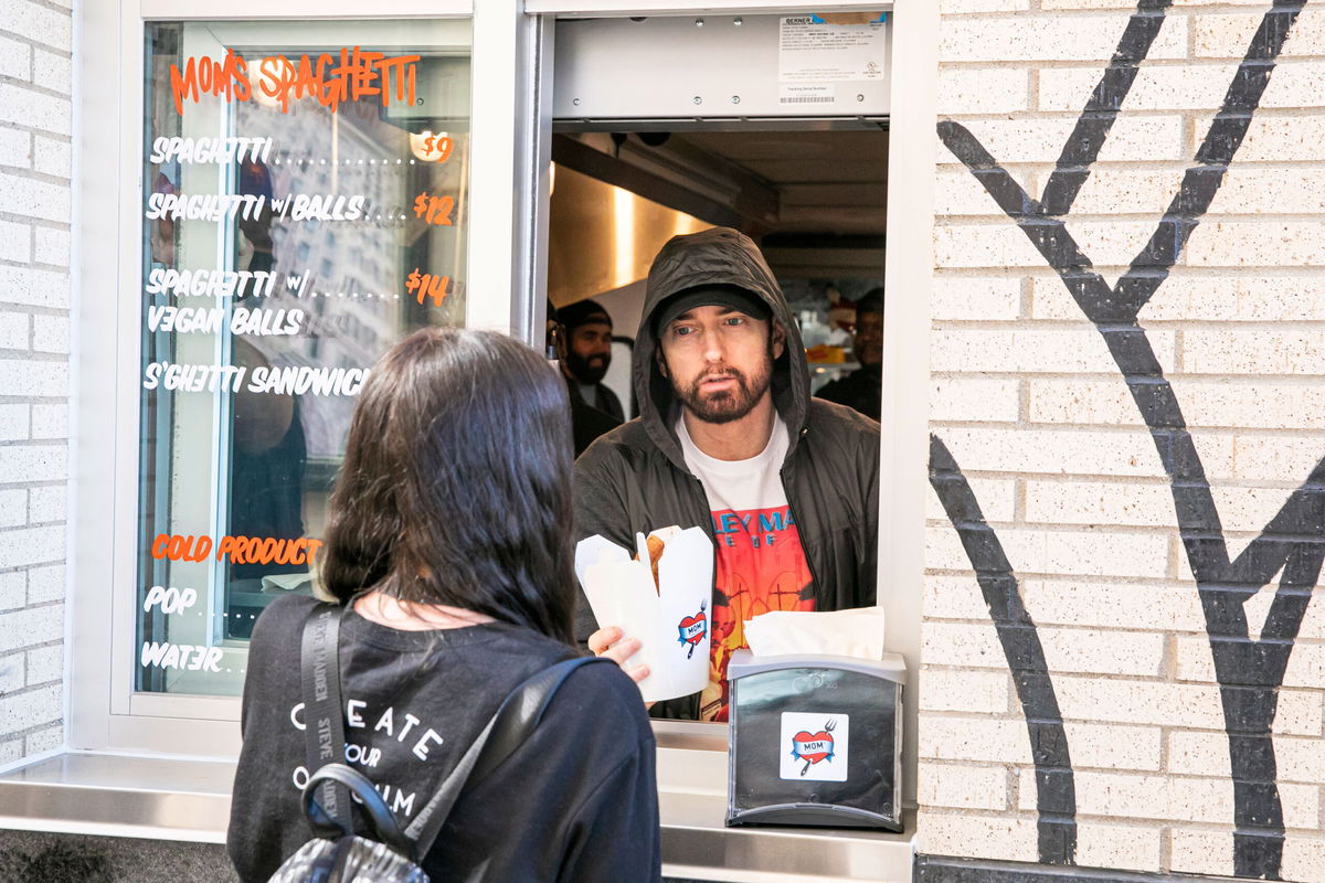 Eminem serves Mom's Spaghetti to a fan on the opening night of his restaurant 