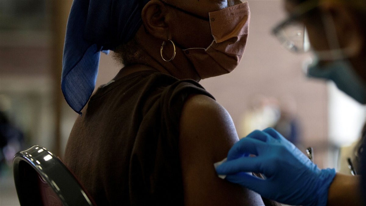 <i>Emily Elconin/Reuters</i><br/>A nurse sanitizes a patient's arm before administering a Covid-19 vaccine booster during a Pfizer-BioNTech vaccination clinic in Southfield