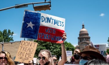 A federal judge Friday questioned Texas abortion ban's controversial enforcement mechanism. Abortion protesters hold up signs outside the Texas state capitol on May 29