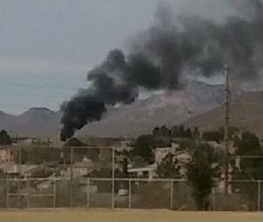 Smoke rises from the roof of a home on fire in Las Cruces.