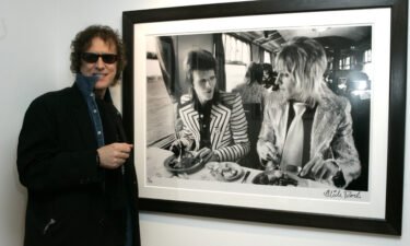 Mick Rock with his photo of David Bowie and Mick Ronson.
