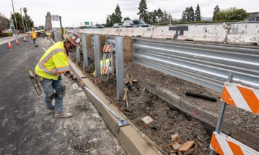 A contractor works on a road under repair along Highway 101 in San Mateo