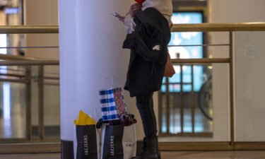 American households are carrying record amounts of debt as home and auto prices surge. A shopper is shown here with retail bags inside the Westfield San Francisco Centre shopping mall in San Francisco