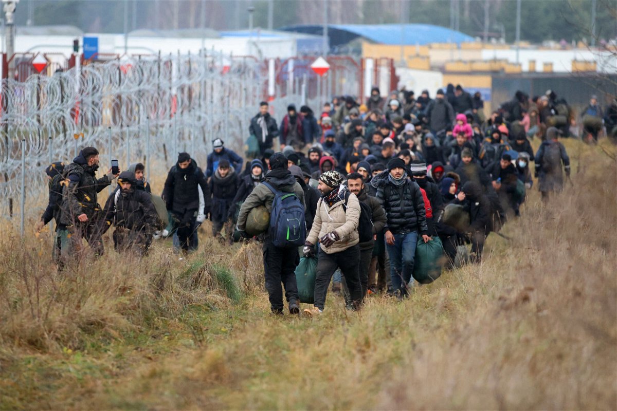 <i>Leonid Shcheglov/Belta/AFP/Getty Images</i><br/>A group of migrants walk along the Belarusian-Polish border in Belarus' Grodno region on November 12.