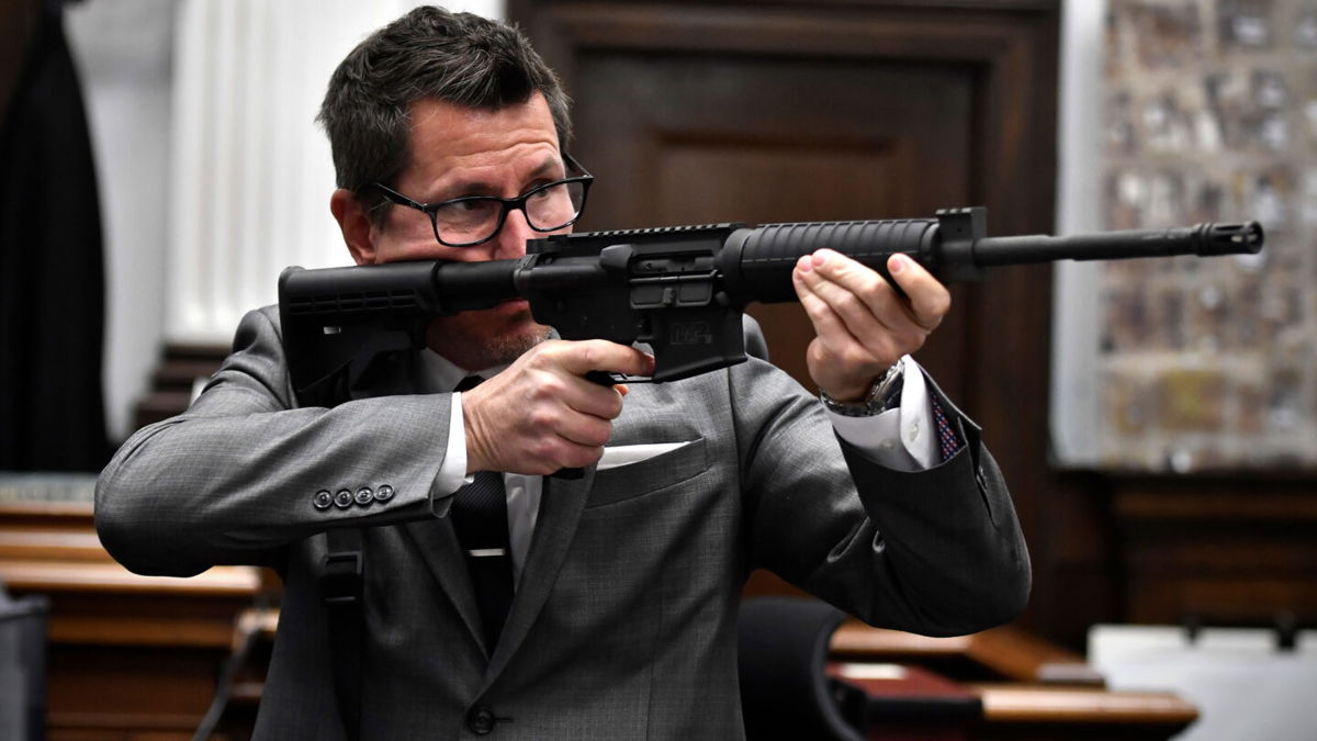 <i>Sean Krajacic/The Kenosha News/Pool/AP</i><br/>Assistant District Attorney Thomas Binger holds Kyle Rittenhouse's gun as he gives the state's closing argument on Monday