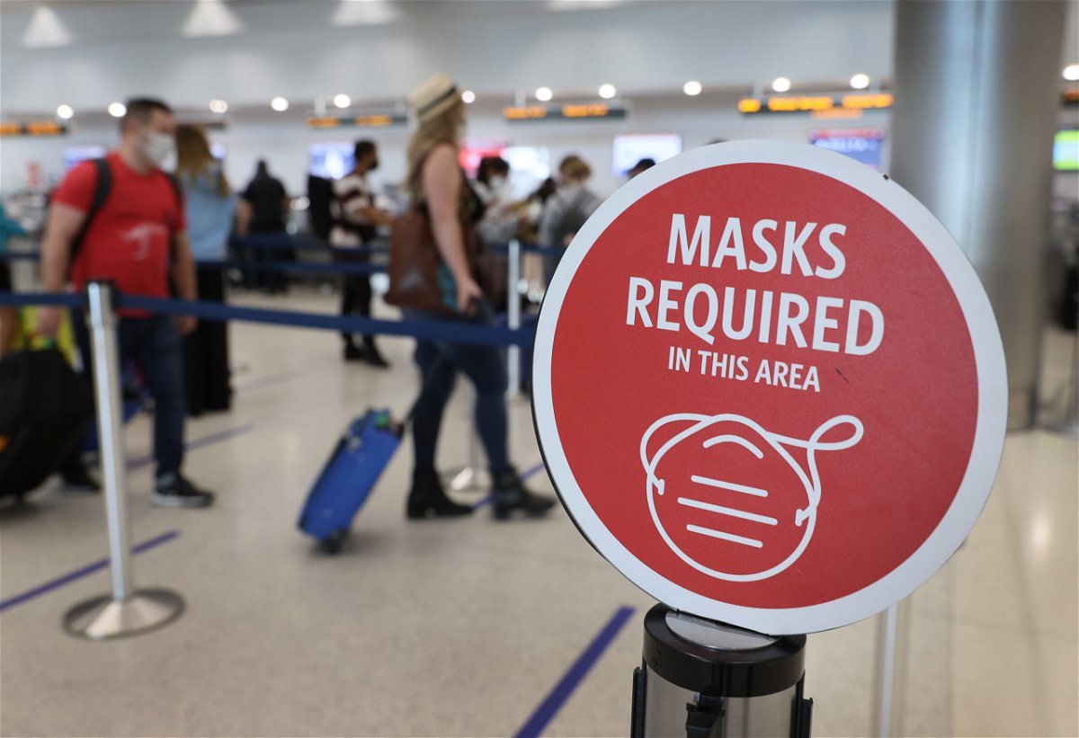 <i>Joe Raedle/Getty Images</i><br/>A sign about the federal mask requirement is seen as travelers prepare to check in at Miami International Airport on February 01