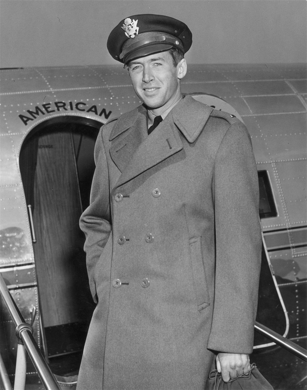 <i>Hulton Archive/Archive Photos/Getty Images</i><br/>Stewart in the early 1940s with his Air Force cap in front of a military plane.