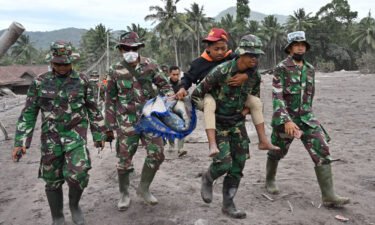 Members of a search and rescue team carry a villager during an operation at the Sumberwuluh village on December 6.
