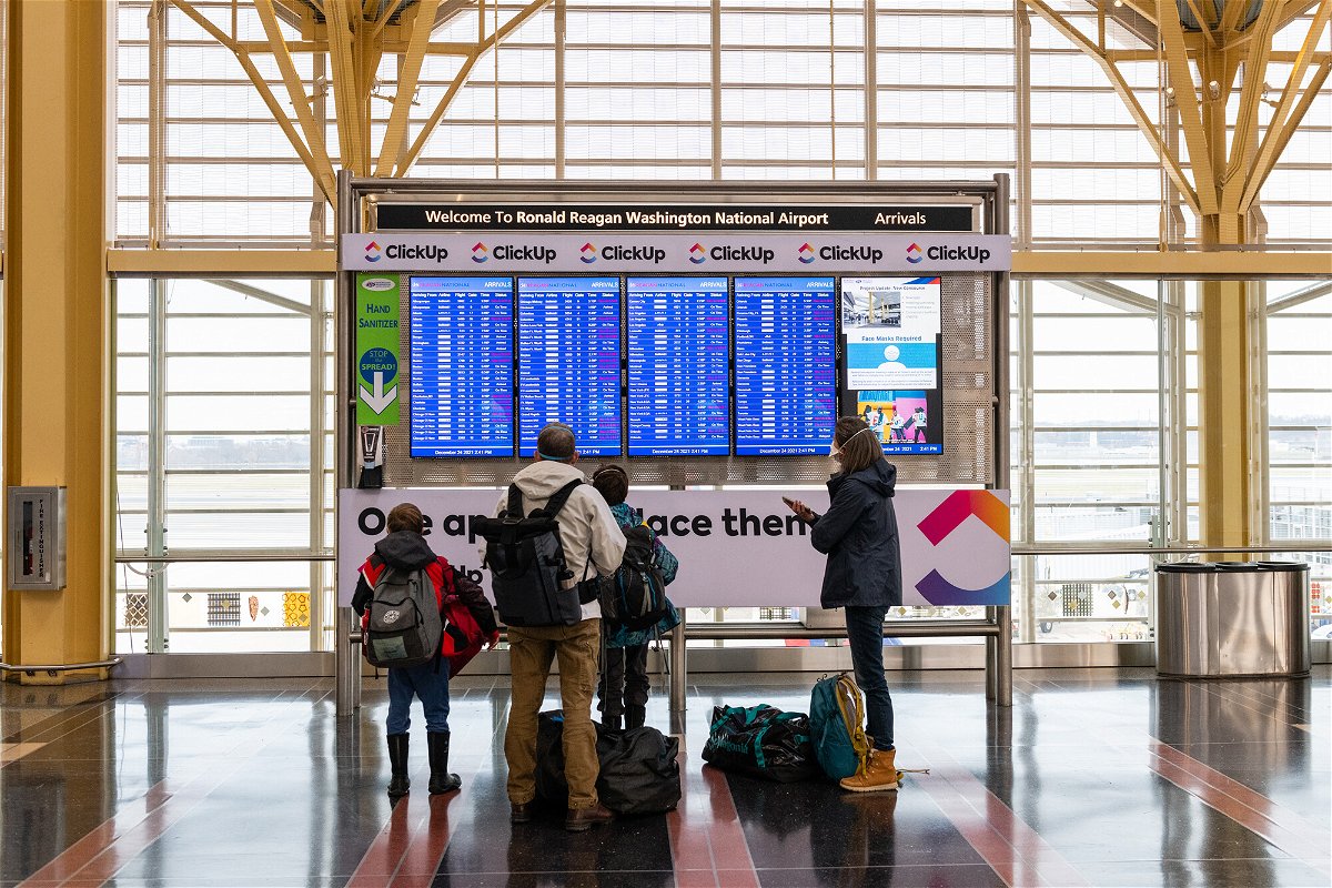 <i>Eric Lee/Bloomberg/Getty Images</i><br/>A family looks at flight information at Reagan National Airport in Arlington